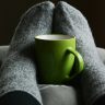 Green Ceramic Mug on Person's Feet