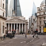 A vibrant street in London with historical architecture and bustling pedestrians.