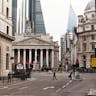 A vibrant street in London with historical architecture and bustling pedestrians.